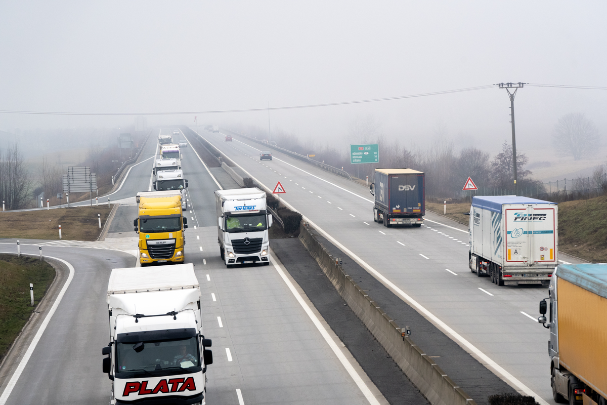 Heavy freight traffic on the D5 motorway in the Czech Republic, with trucks in adjacent lanes and reduced visibility from fog