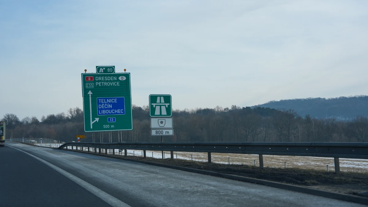 Czech D8 motorway direction signs to Dresden and Petrovice on E55 with vignette required warning sign indicating vignette enforcement begins in 800 metres ahead, February 2026