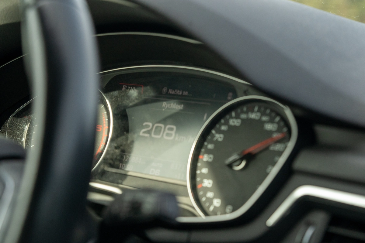 Czech-language car dashboard ('Rychlost') displaying 208 km/h on a German Autobahn unrestricted section heading towards Dresden, showing the contrast between Czech motorway rules (130 km/h limit, vignette required) and the German Autobahn (no speed limit, no passenger car toll), March 2026