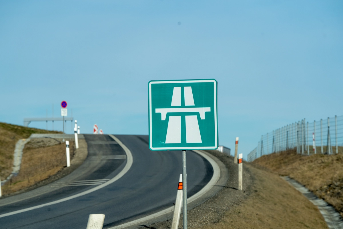 Czech green motorway entry sign on a curving slip road joining the D3 motorway near České Budějovice, with overhead gantry visible in the distance — marking the point where the Czech e-vignette obligation begins, February 2026