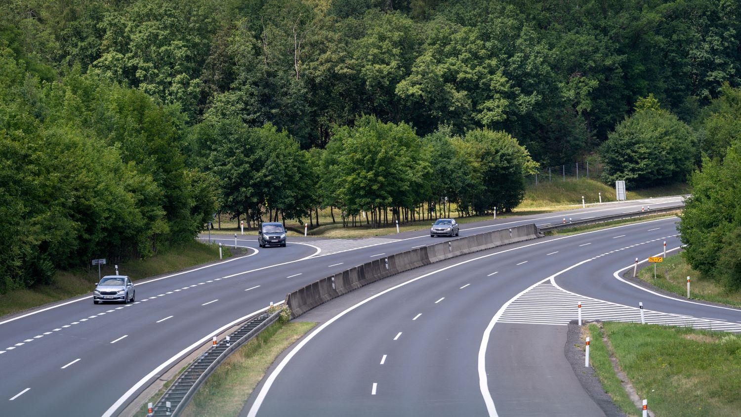 The D8 between Prague and Dresden seen from a bridge, curving through forest near km 74.5, where cars need a Czech e-vignette