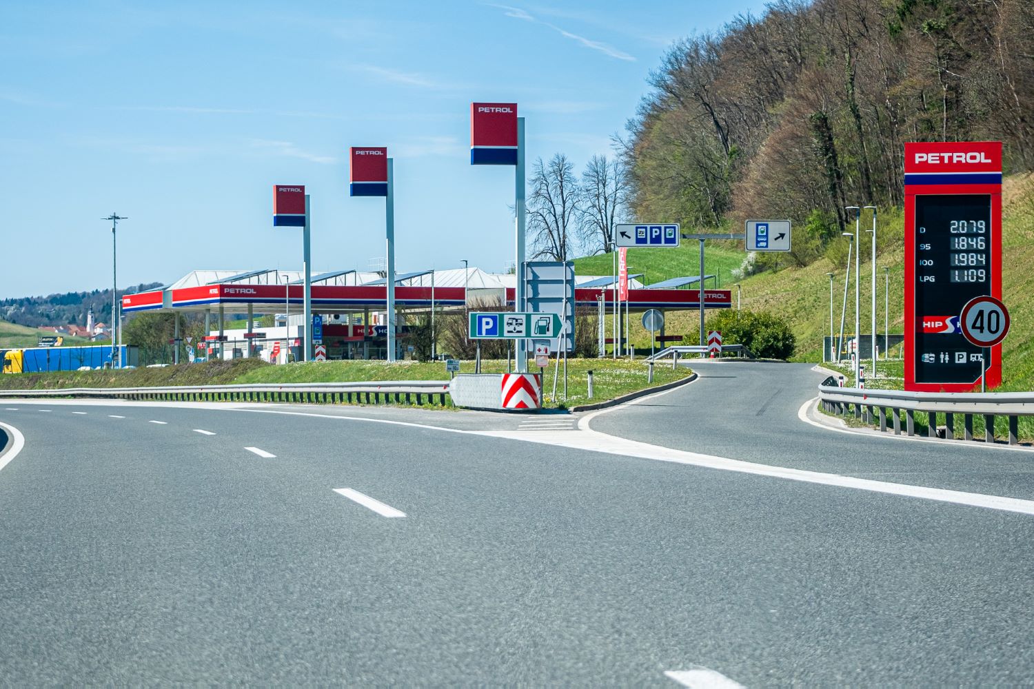 Exit to a Petrol motorway service station in Slovenia, with fuel prices on display, for drivers using the Slovenian e-vignette